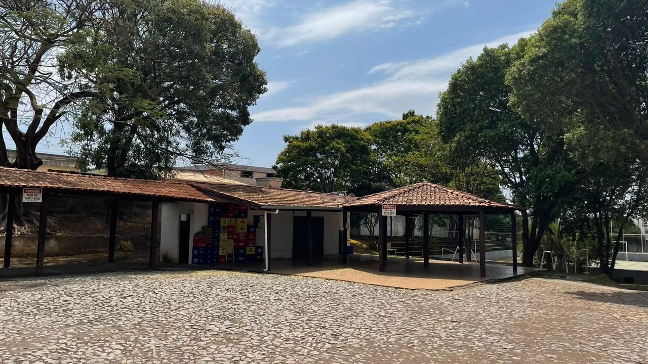 Área de lazer com quiosques cobertos e piso em pedra portuguesa após intervenção